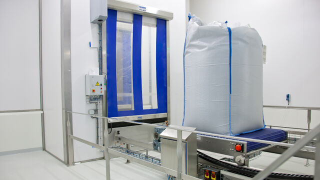 TBMA double air lock system for transfer of filled bigbags from hi-care to lo-care area